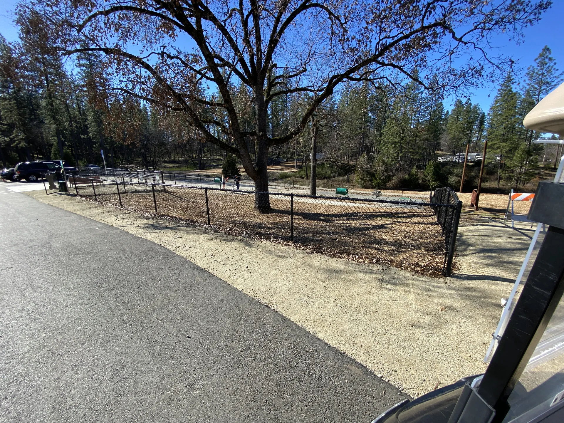 Paved walking path beside the fenced dog park at Grass Valley RV Resort